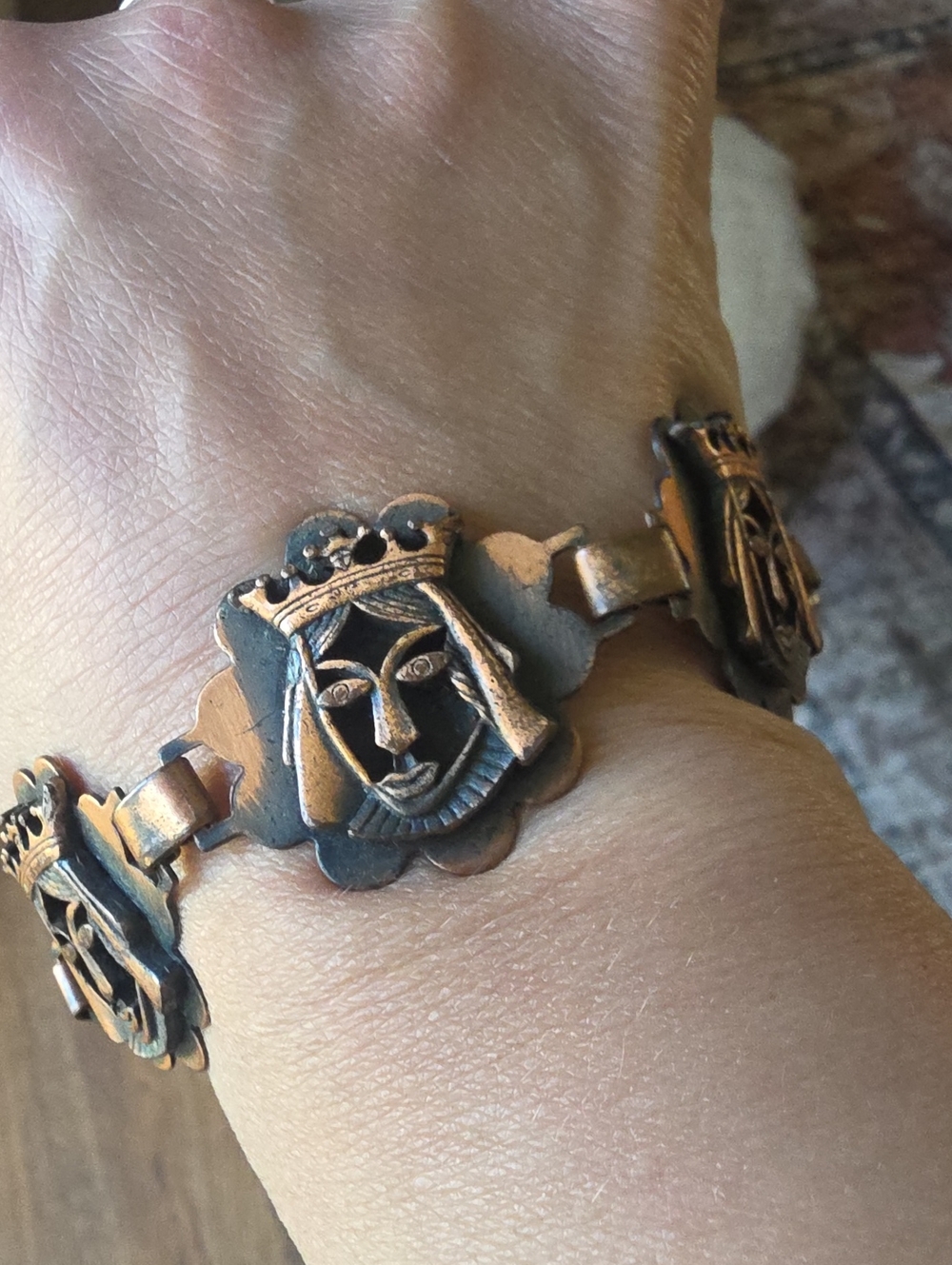 Vintage copper link bracelet featuring stylized royal faces.
